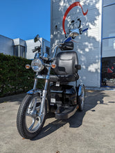 Afbeelding in Gallery-weergave laden, Een foto van de Sportrider scootmobiel waarbij hij buiten staat in het zonnetje