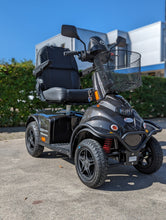 Afbeelding in Gallery-weergave laden, De Minicrosser scootmobiel die buiten in het zonnetje staat in de grijze uitvoering